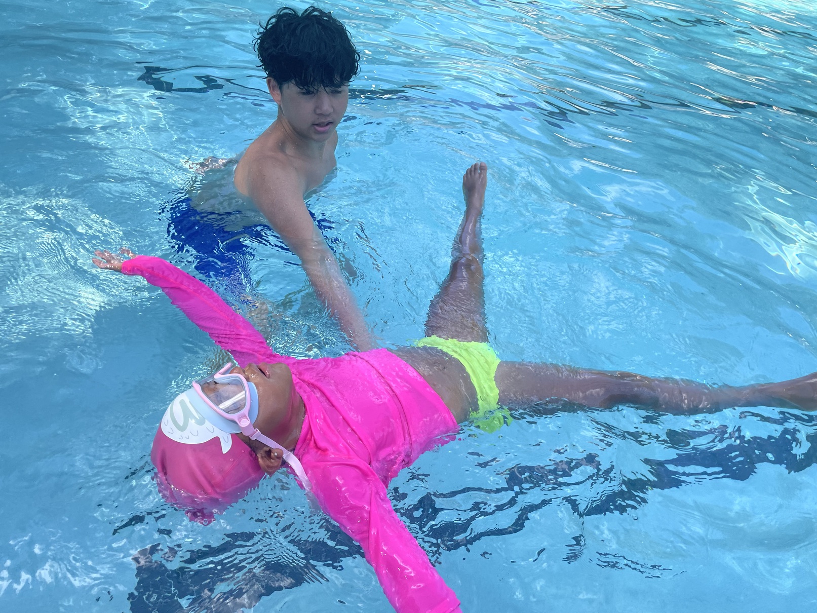 A child learning to float on their back