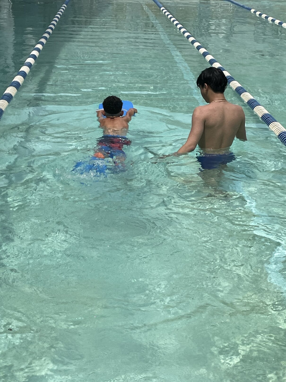 A child holding a swimming kickboard