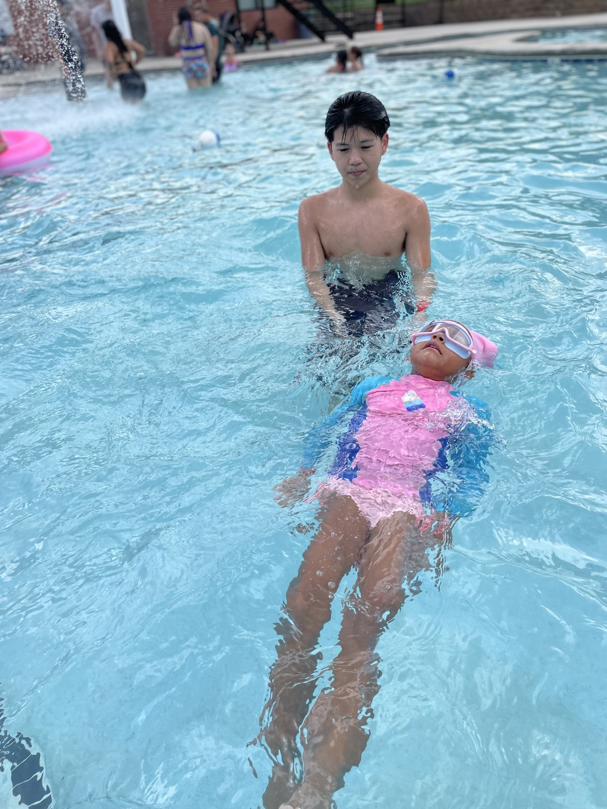 A child floating on their back in the pool
