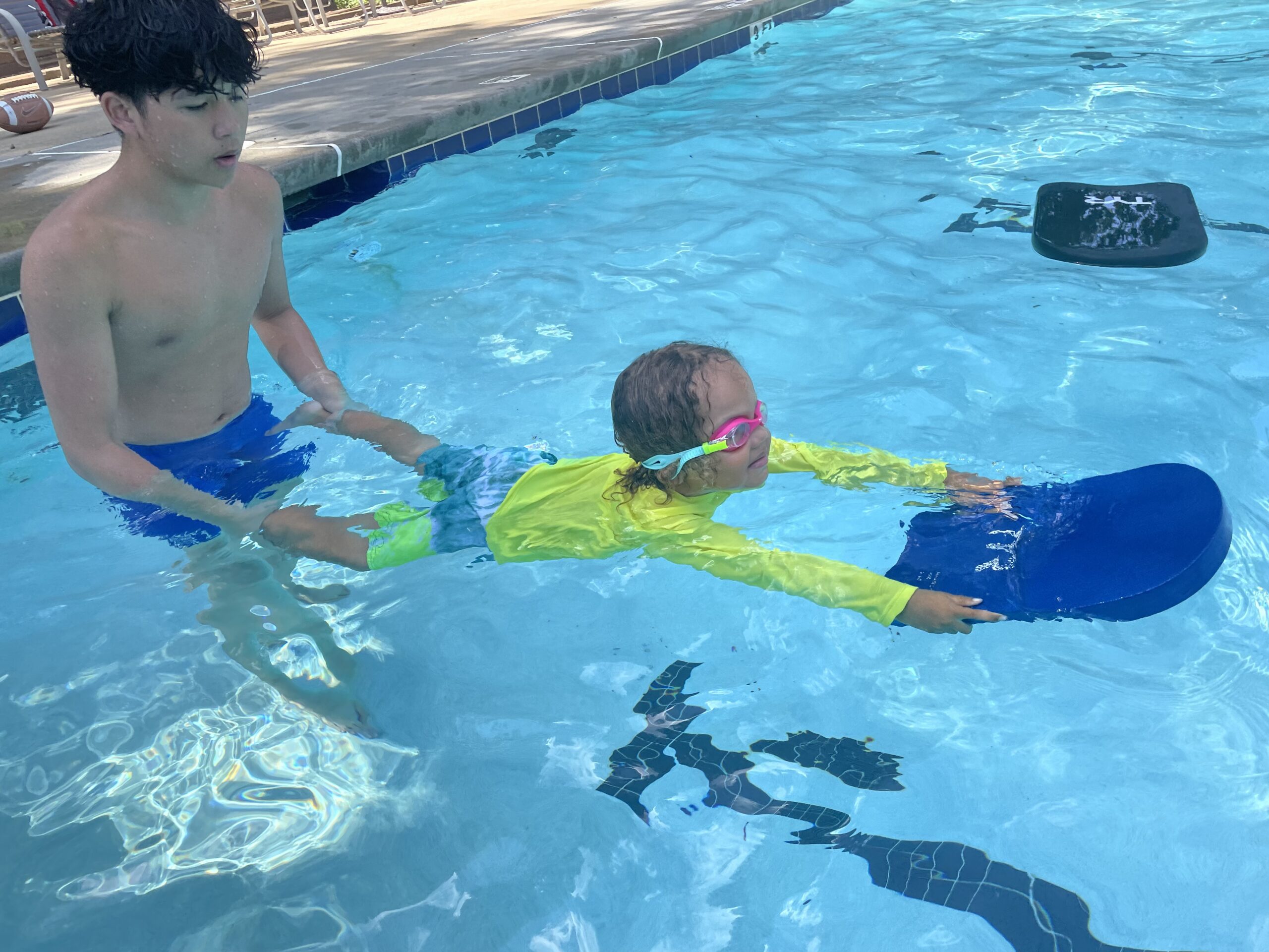 An instructor helping a child learn to swim