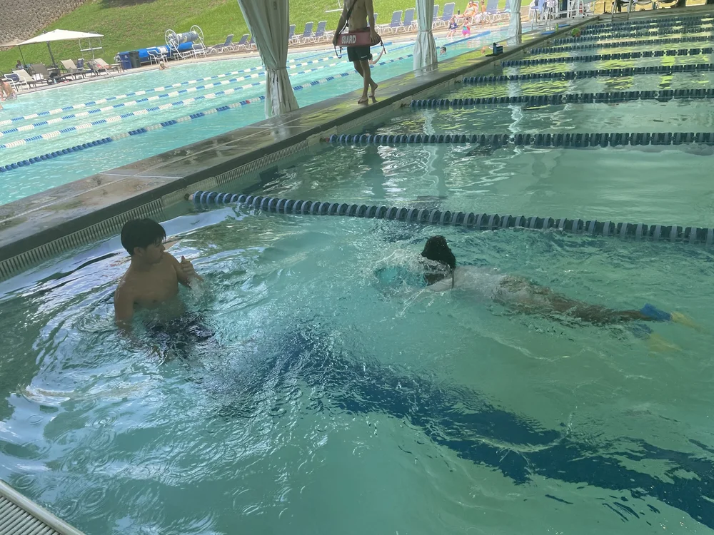 An instructor supporting a young swimmer in the pool