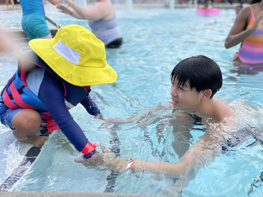 Founder Clinton helping a young swimmer into the pool